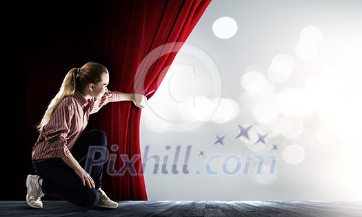 Young woman in casual opening red curtain