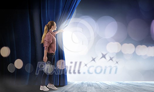 Young woman in casual opening blue curtain