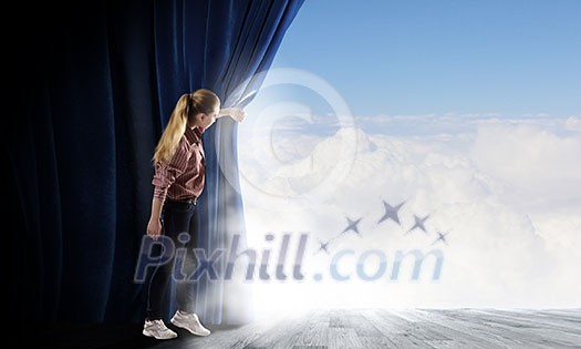 Young woman in casual opening blue curtain and looking at clear sky
