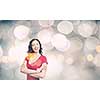 Young woman in red dress against bokeh background