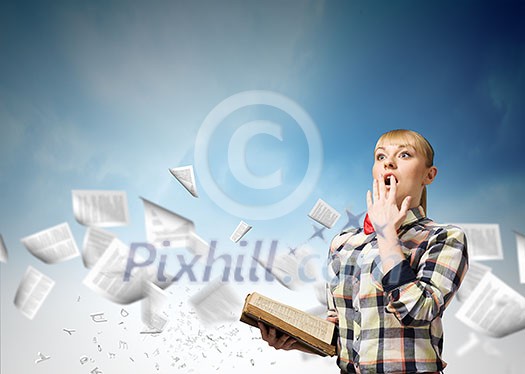 Woman in casual wear holding opened book in hands Woman in casual wear holding opened book in hands