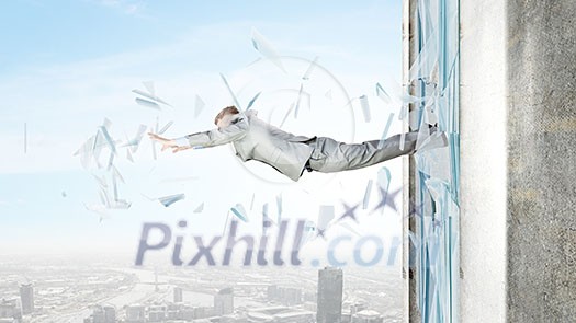 Businessman jumping through glass window of office Businessman jumping through glass window of office