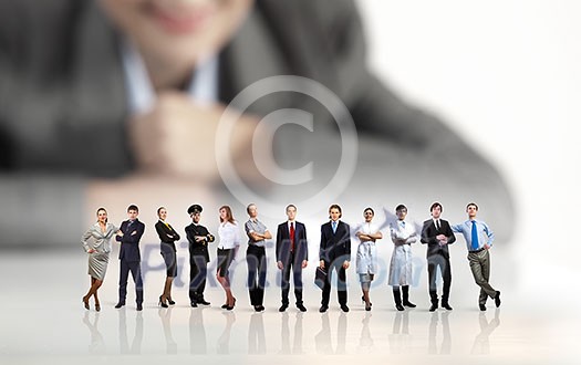 Businesswoman looking at group of businesspeople in miniature Businesswoman looking at group of businesspeople in miniature
