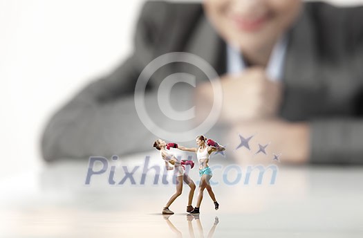 Businesswoman looking at two sport girls boxing in gloves Businesswoman looking at two sport girls boxing in gloves