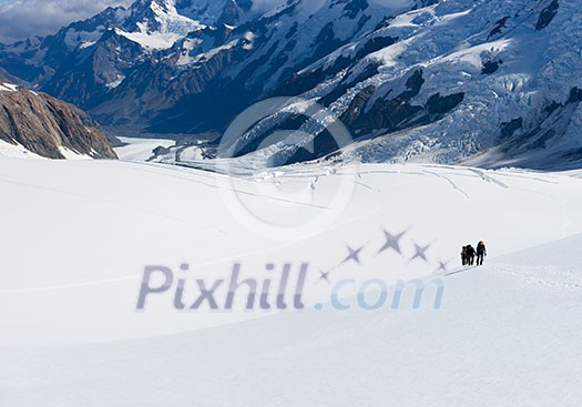 Group of people walking among snows of New Zealand Alps Group of people walking among snows of New Zealand Alps