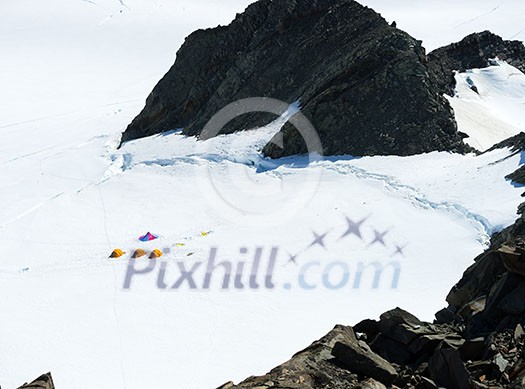 Mountain landscape with three tents among snows