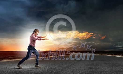 Young man in casual throwing fire ball