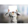 Businesswoman hiding her face behind blank paper sheet
