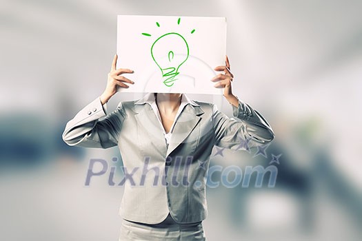 Businesswoman hiding her face behind paper sheet with sketches Businesswoman hiding her face behind paper sheet with sketches