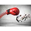 Boxing glove on spring striking group of businesspeople
