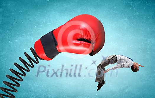 Young determined businessman fighting boxing glove on spring