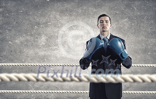 Determined businessman in suit and boxing gloves Determined businessman in suit and boxing gloves
