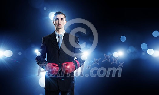 Determined businessman in suit and boxing gloves Determined businessman in suit and boxing gloves