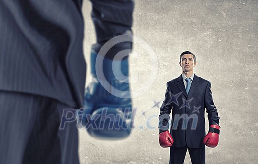 Determined businessman in suit and boxing gloves Determined businessman in suit and boxing gloves