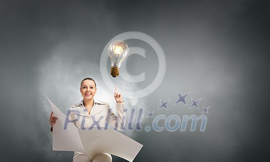 Portrait of young businesswoman in white suit reading blank newspaper