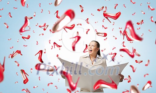 Portrait of young businesswoman in white suit reading blank newspaper