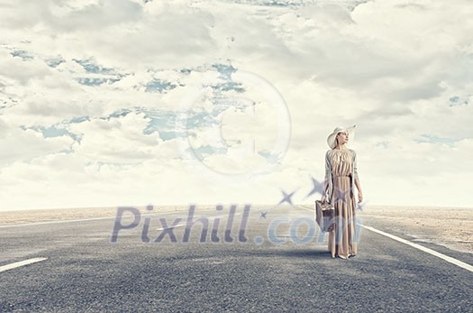 Beautiful woman with retro suitcase walking on road Beautiful woman with retro suitcase walking on road