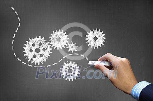 Businessman hand drawing with chalk gears mechanism as teamwork concept Businessman hand drawing with chalk gears mechanism as teamwork concept