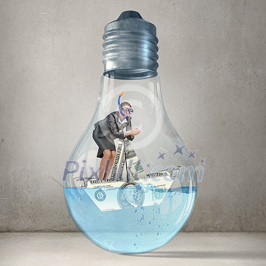 Young businesswoman in suit and diving mask jumping in lightbulb with water