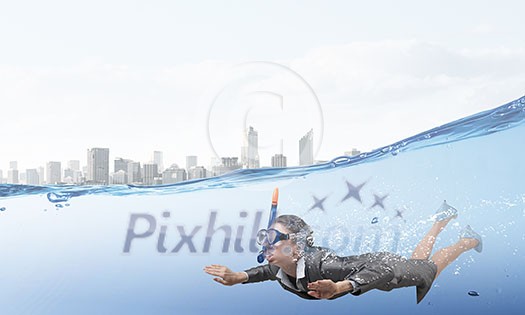 Young businesswoman in suit and diving mask swimming under water Young businesswoman in suit and diving mask swimming under water