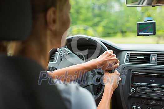 Young woman driving her car, on her way home from work - doing the daily commute Young woman driving her car, on her way home from work - doing the daily commute