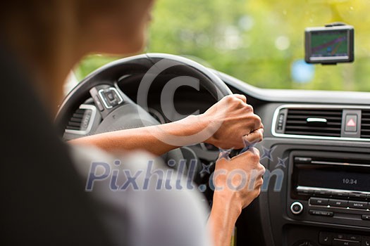 Young woman driving her car, on her way home from work - doing the daily commute Young woman driving her car, on her way home from work - doing the daily commute