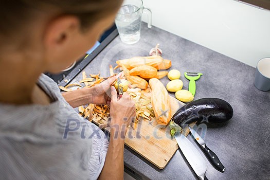 Young woman cooking in her modern kitchen (shallow DOF; color toned image)