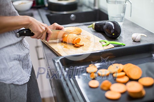 Young woman cooking in her modern kitchen (shallow DOF; color toned image)