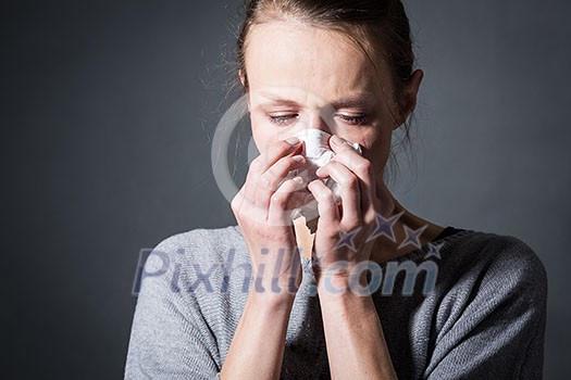 Young woman suffering from severe depression/anxiety/sadness, crying, tears coming from her eyes, blowing her nose Young woman suffering from severe depression/anxiety/sadness, crying, tears coming from her eyes, blowing her nose