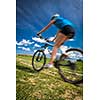 Pretty, young female biker outdoors on her mountain bike (motion blurred image)