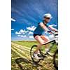 Pretty, young female biker outdoors on her mountain bike (motion blurred image)