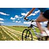 Pretty, young female biker outdoors on her mountain bike (motion blurred image)