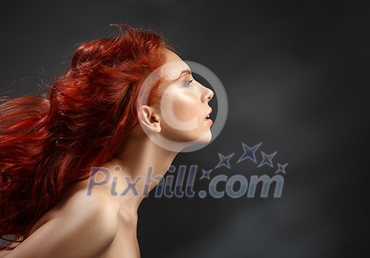 red-haired girl with flying hair on dark background