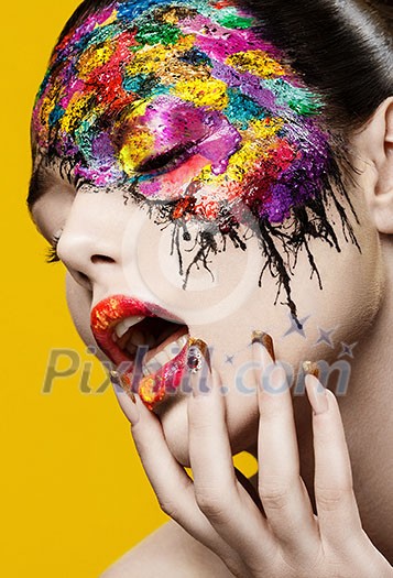 Beautiful fashion woman color face-art on yellow background