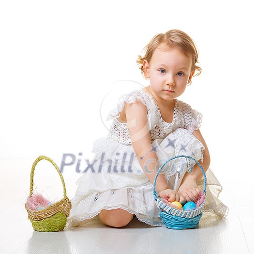 Little girl collects Easter eggs in a basket.