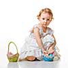Little girl collects Easter eggs in a basket.