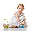 Little girl collects Easter eggs in a basket.