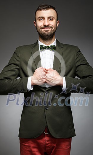 happy young man in a green suit on a gray background happy young man in a green suit on a gray background