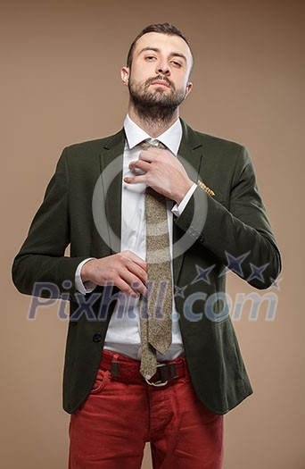 young man in a green suit and tie, beige background