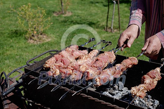 Preparation of shish kebabs outdoors. Lunch in a country house. Picnic in weekend.