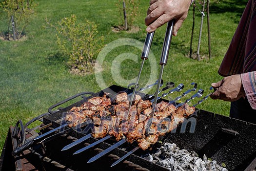 Preparation of shish kebabs outdoors. Lunch in a country house. Picnic in weekend.