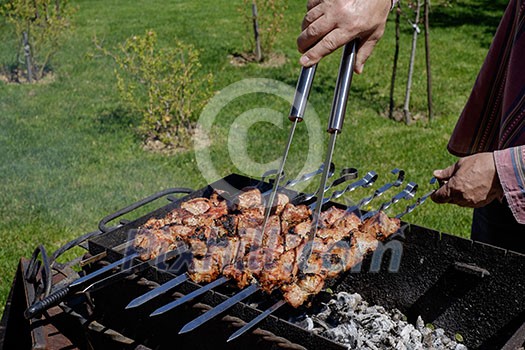 Preparation of shish kebabs outdoors. Lunch in a country house. Picnic in weekend. Preparation of shish kebabs outdoors. Lunch in a country house. Picnic in weekend.