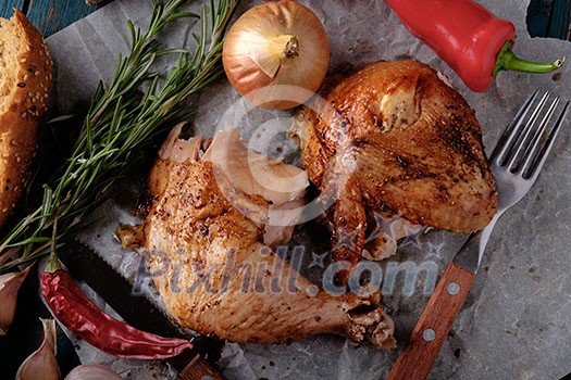 Roasted chicken leg and wing with chili on a wooden table. Tasty food. Rustic style. Roasted chicken leg and wing with chili on a wooden table. Tasty food. Rustic style.
