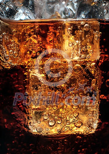 Bubbles in the glass of cola with ice. Close-up. Bubbles in the glass of cola with ice. Close-up.
