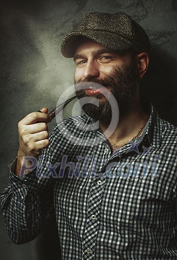 Portrait of young stylish man with a beard with a pipe. Portrait of young stylish man with a beard with a pipe.