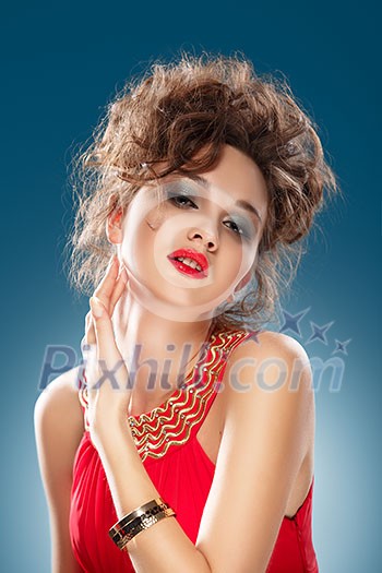 Beauty Portrait. Beautiful Woman in Red Dress Touching her Face. Perfect Fresh Skin. Blue background. Beauty Portrait. Beautiful Woman in Red Dress Touching her Face. Perfect Fresh Skin. Blue background.