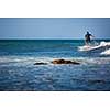 Young boy surfing the wave in a sunny day