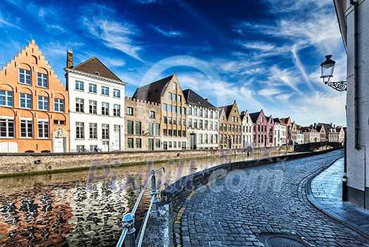 Europe travel background - street along canal and medieval houses. Bruges (Brugge), Belgium Europe travel background - street along canal and medieval houses. Bruges (Brugge), Belgium