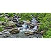 Woman practices balance yoga asana Vrikshasana tree pose at waterfall outdoors. Himachal Pradesh, India. Panorama