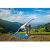 Sporty fit woman practices yoga asana Utthita Parsvakonasana -  extended side angle pose outdoors in mountains in the  morning